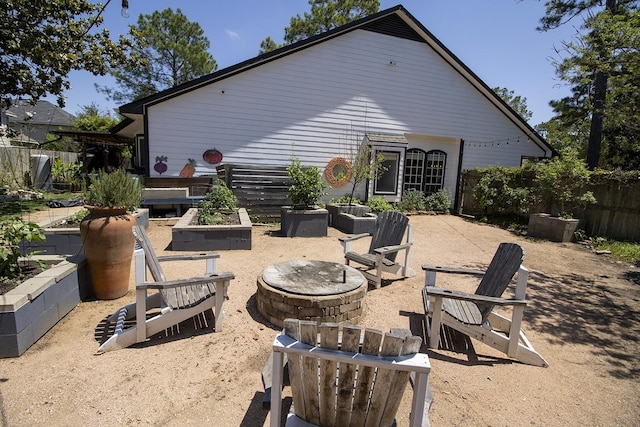 view of patio / terrace with an outdoor fire pit, a vegetable garden, and fence