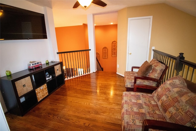 living area featuring an upstairs landing, wood finished floors, ceiling fan, and lofted ceiling