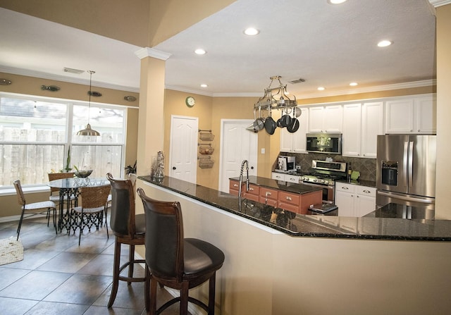 kitchen featuring stainless steel appliances, crown molding, recessed lighting, decorative backsplash, and white cabinets