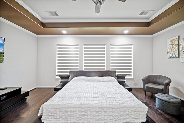 bedroom featuring a tray ceiling, crown molding, wood finished floors, and visible vents