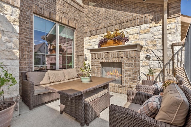 view of patio with an outdoor living space with a fireplace