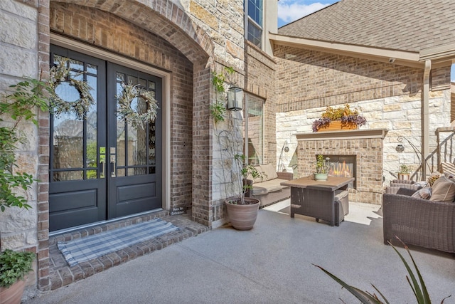 property entrance with a patio, french doors, and an outdoor living space with a fireplace