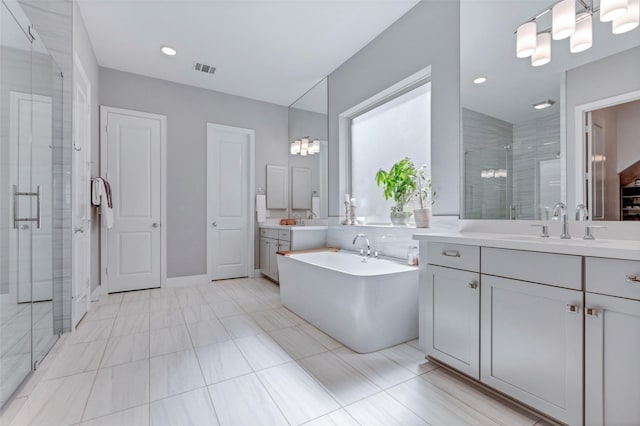 full bathroom with visible vents, a sink, a soaking tub, two vanities, and a stall shower