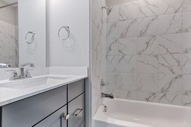 bathroom featuring a textured wall, shower / bath combination, and vanity