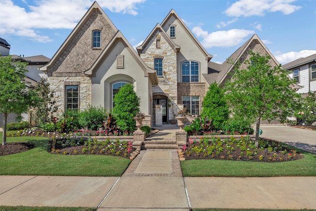 french provincial home featuring stucco siding and stone siding