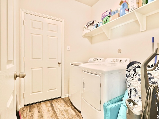 laundry area featuring washer and clothes dryer, light wood-style floors, and laundry area