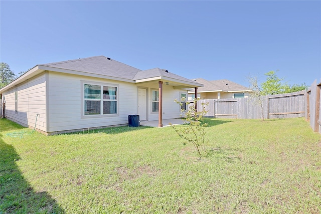rear view of house with a patio area, fence, and a lawn