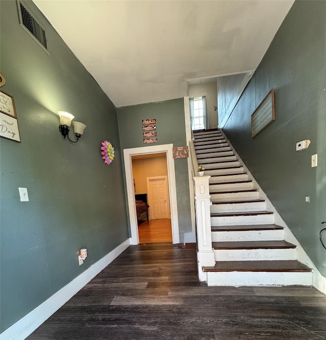 stairs featuring wood finished floors and baseboards