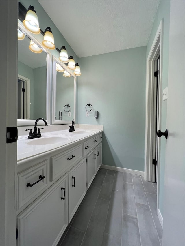 15903 Brookvilla Dr, Houston, TX 77059 - bathroom featuring tile patterned floors, double vanity, a sink, and baseboards