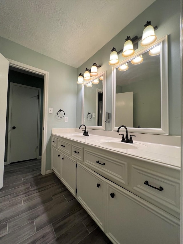 15903 Brookvilla Dr, Houston, TX 77059 - full bathroom featuring a sink, double vanity, wood finish floors, and a textured ceiling