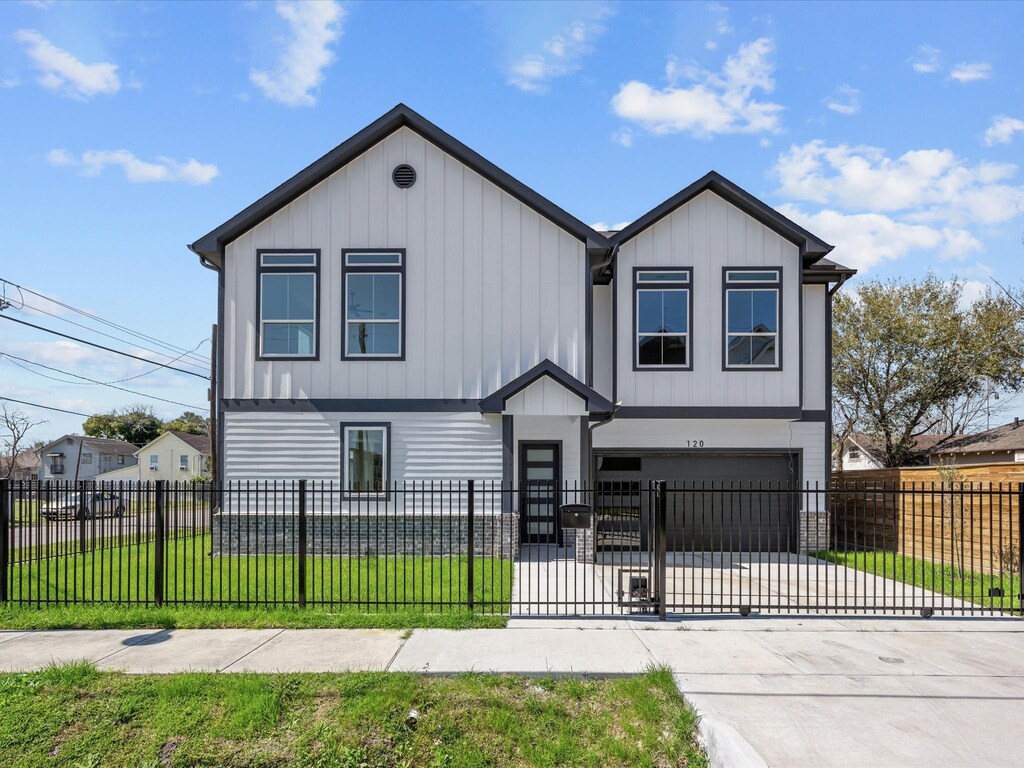 120 Adams St, Houston, TX 77011 - modern farmhouse featuring board and batten siding, a garage, a fenced front yard, and driveway