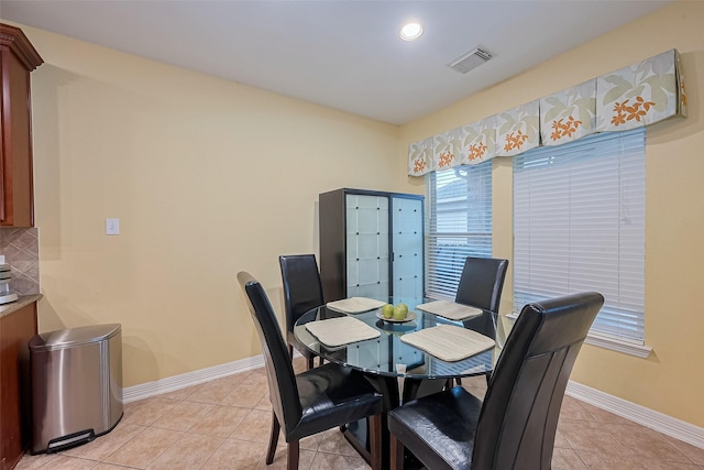 dining area featuring light tile patterned floors, baseboards, and visible vents