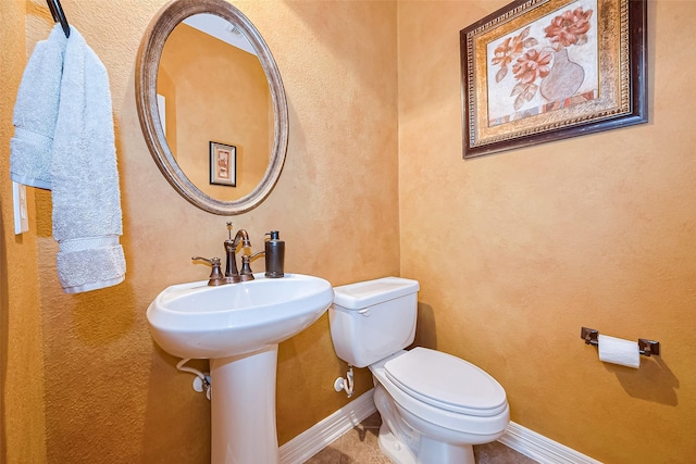 bathroom with baseboards and toilet