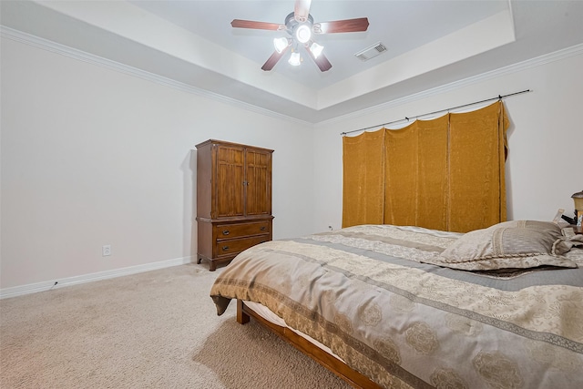 bedroom with visible vents, baseboards, a raised ceiling, ceiling fan, and light colored carpet
