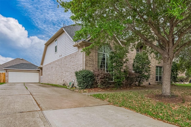 view of home's exterior with a garage, brick siding, and driveway