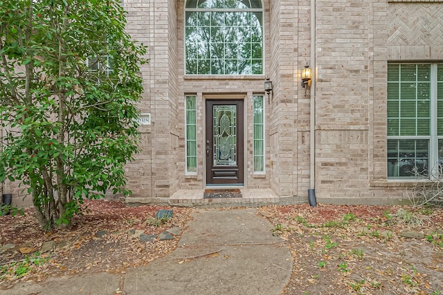 property entrance featuring brick siding