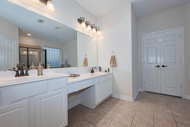 bathroom with visible vents, double vanity, a stall shower, and tile patterned flooring