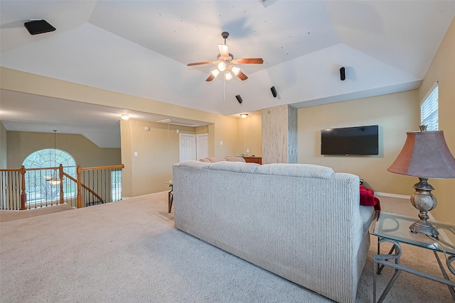 living room with carpet floors, ceiling fan, attic access, and lofted ceiling