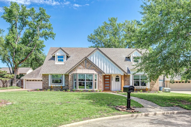 tudor home with a front yard, brick siding, roof with shingles, and board and batten siding