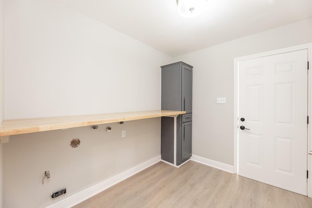 clothes washing area featuring laundry area, light wood finished floors, and baseboards