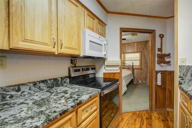 kitchen with wooden walls, ornamental molding, white microwave, and electric stove