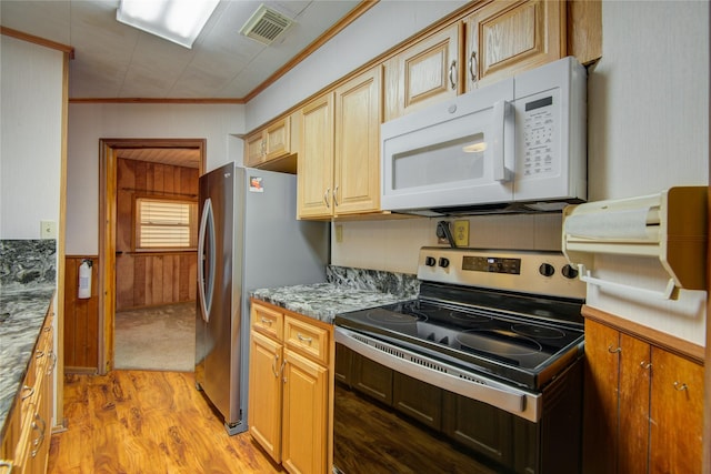 kitchen with light wood-style flooring, crown molding, wood walls, visible vents, and stainless steel appliances
