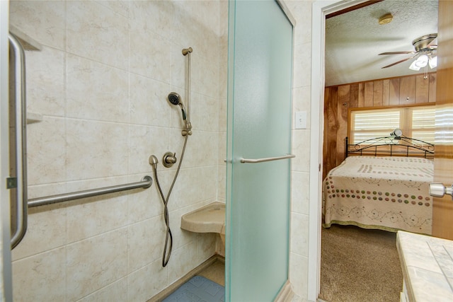 ensuite bathroom with ensuite bath, wooden walls, a textured ceiling, a shower stall, and ceiling fan