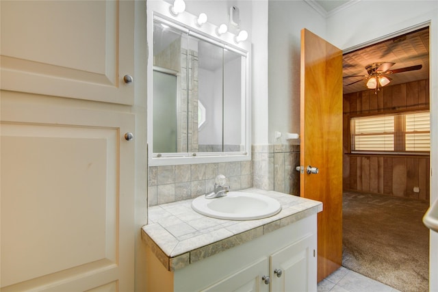 bathroom featuring vanity, tile patterned floors, backsplash, wood walls, and ceiling fan