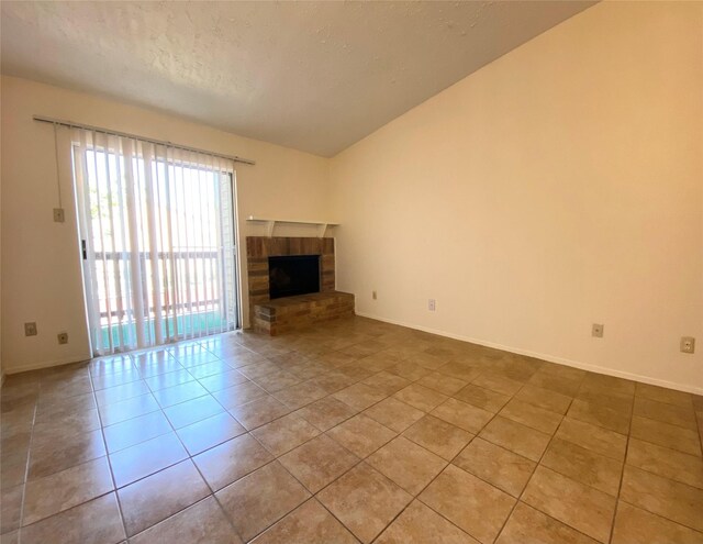 10555 Turtlewood Ct Unit 903, Houston, TX 77072 - unfurnished living room with baseboards, tile patterned floors, a textured ceiling, and vaulted ceiling