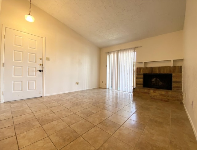 10555 Turtlewood Ct Unit 903, Houston, TX 77072 - unfurnished living room featuring a fireplace, a textured ceiling, tile patterned flooring, lofted ceiling, and baseboards
