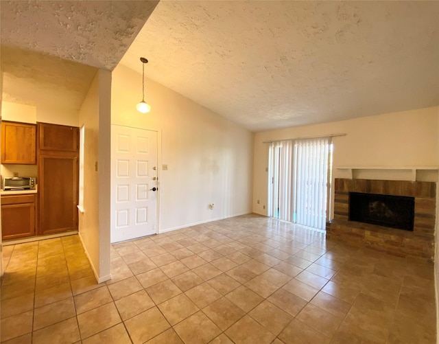 10555 Turtlewood Ct Unit 903, Houston, TX 77072 - unfurnished living room featuring baseboards, a brick fireplace, a textured ceiling, a toaster, and light tile patterned flooring