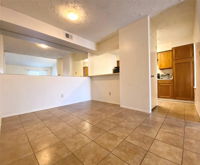 10555 Turtlewood Ct Unit 903, Houston, TX 77072 - spare room with a textured ceiling, light tile patterned floors, baseboards, and visible vents