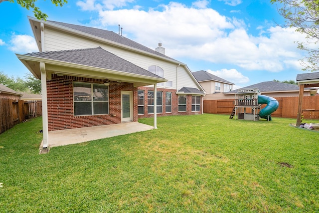 24807 Mason Trail Dr, Katy, TX 77493 - back of property featuring a shingled roof, a patio area, a playground, and brick siding