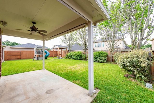24807 Mason Trail Dr, Katy, TX 77493 - view of yard featuring a ceiling fan, a patio area, a fenced backyard, and a playground