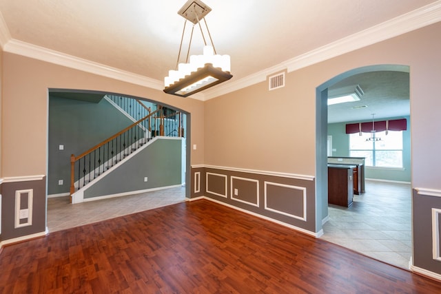 24807 Mason Trail Dr, Katy, TX 77493 - unfurnished room featuring ornamental molding, stairway, visible vents, arched walkways, and wood finished floors