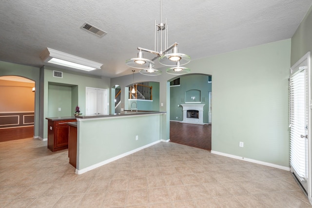 24807 Mason Trail Dr, Katy, TX 77493 - kitchen with a sink, visible vents, arched walkways, and light tile patterned floors
