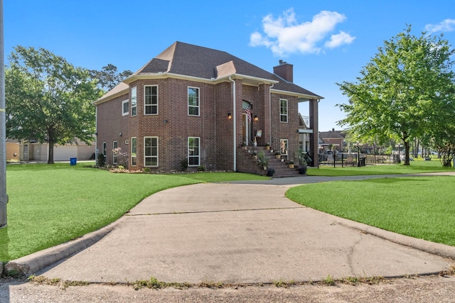 2906 Penninsula Pt, Montgomery, TX 77356 - view of front of house with a front yard, a chimney, brick siding, and roof with shingles
