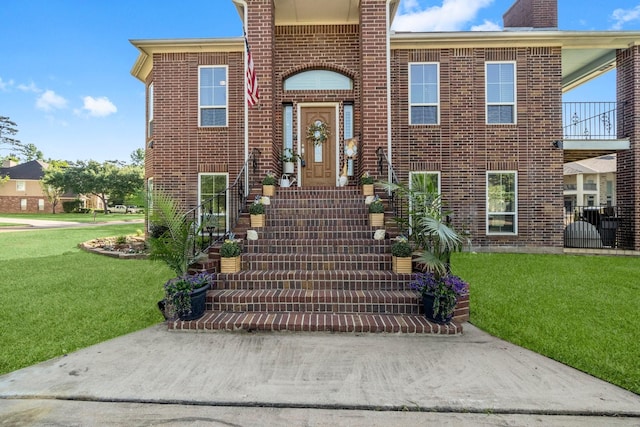 2906 Penninsula Pt, Montgomery, TX 77356 - view of front of house with brick siding, a front lawn, and a chimney