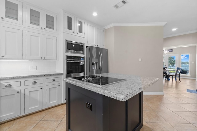 2906 Penninsula Pt, Montgomery, TX 77356 - kitchen featuring stainless steel appliances, light tile patterned floors, crown molding, white cabinetry, and backsplash