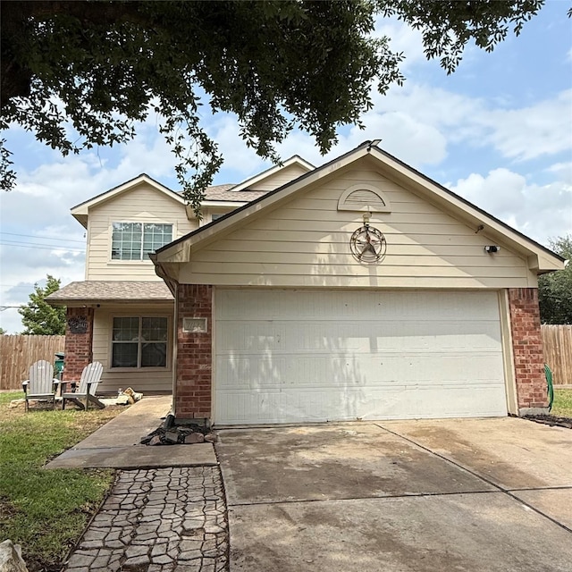 view of front of home with fence, concrete driveway, a garage, and brick siding