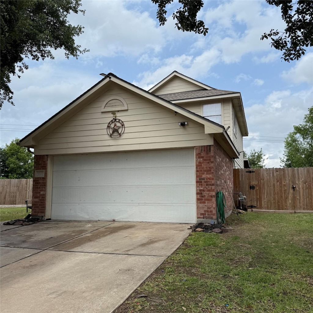 view of side of property with brick siding, fence, and driveway