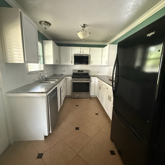11422 Royal Thistle Ct, Houston, TX 77088 - kitchen featuring appliances with stainless steel finishes, a sink, white cabinets, light tile patterned flooring, and a textured ceiling