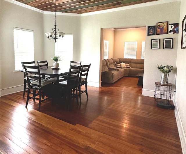dining area featuring crown molding, wood-type flooring, baseboards, and an inviting chandelier