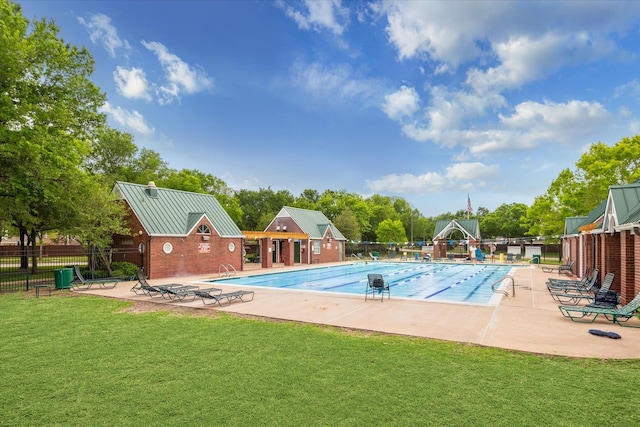 community pool featuring a yard, fence, cooling unit, and a patio