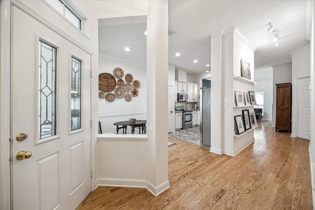 foyer entrance featuring recessed lighting, light wood-style floors, baseboards, and crown molding