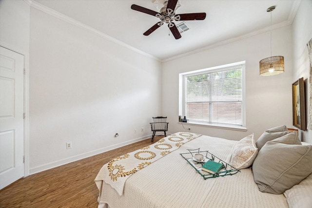 bedroom with visible vents, baseboards, a ceiling fan, crown molding, and wood finished floors