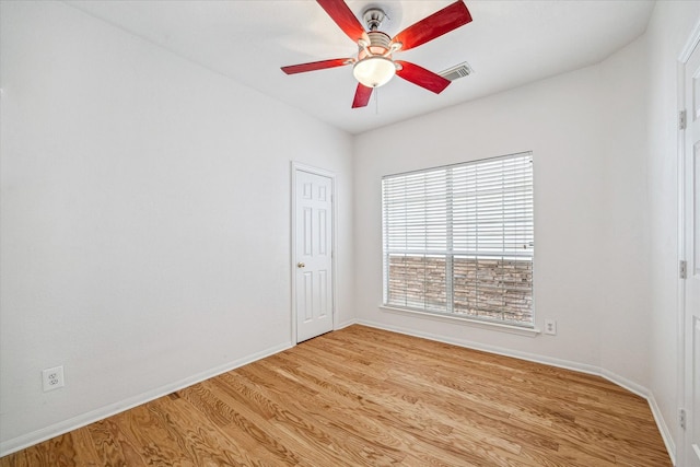 unfurnished room with light wood-style floors, baseboards, visible vents, and a ceiling fan