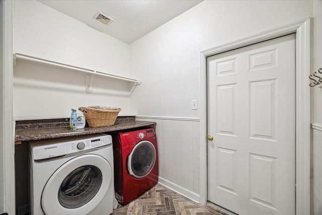 laundry area with independent washer and dryer, laundry area, wainscoting, and visible vents