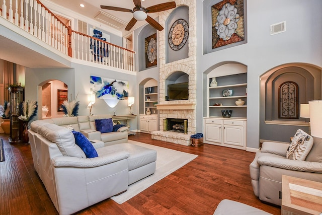 37703 Edgewater Dr, Pinehurst, TX 77362 - living area with a high ceiling, built in features, ceiling fan, wood finished floors, and baseboards