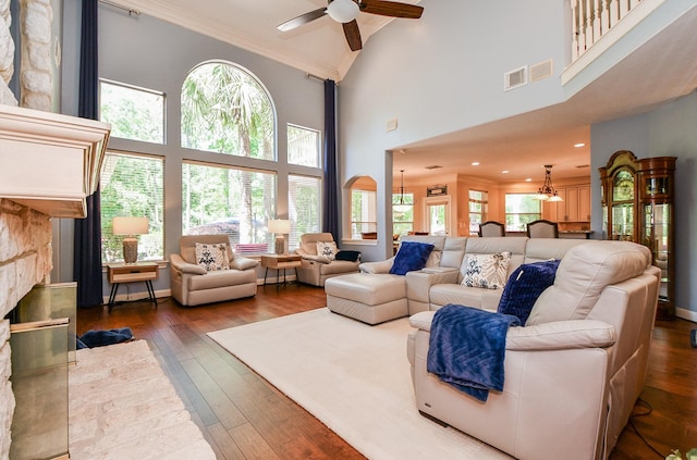 37703 Edgewater Dr, Pinehurst, TX 77362 - living room with crown molding, a chandelier, dark wood-style flooring, ceiling fan, and a towering ceiling